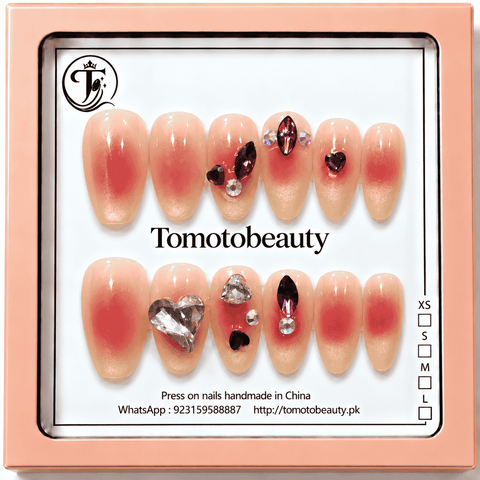 Tomoto Beauty A050 peach nude pink aura press on nails with pink blush center, heart-shaped clear crystal and deep red rhinestone embellishments