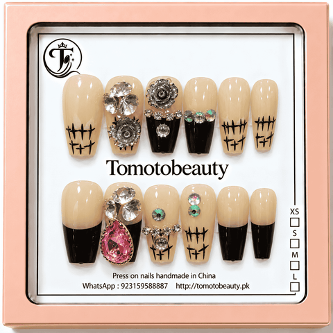 Tomoto Beauty A092 12 ivory nude and black French tip press on nails featuring black stitch line designs, silver rose charms, pink gemstone and sparkling crystals