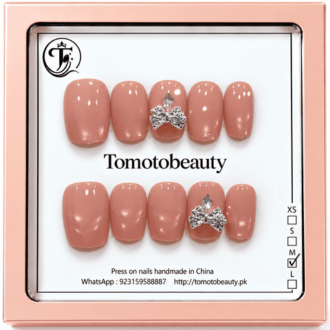 Tomoto Beauty B019: A glossy peach-nude short square nail set with delicate shimmer and sparkling silver crystal bows on feature nails. Pretty, subtle and feminine.