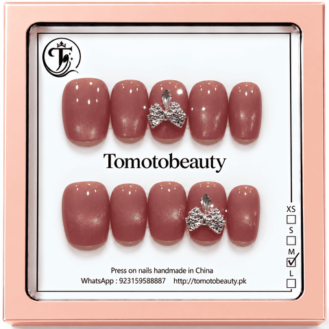 Tomoto Beauty B020: Muted dusty rose mauve shimmer press-on nails with silver rhinestone bow accent details. An elegant, polished short-square manicure.