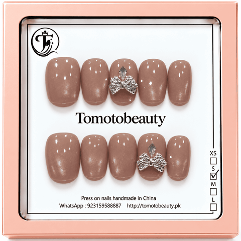 Tomoto Beauty B021: Soft taupe mauve glossy short-square artificial nails finished with a statement silver bow embellishment on an accent nail.