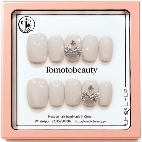 Tomoto Beauty B024: Smooth glossy milky-white short square press-on nails with sparkling silver rhinestone bow accents. A clean bridal-inspired manicure.