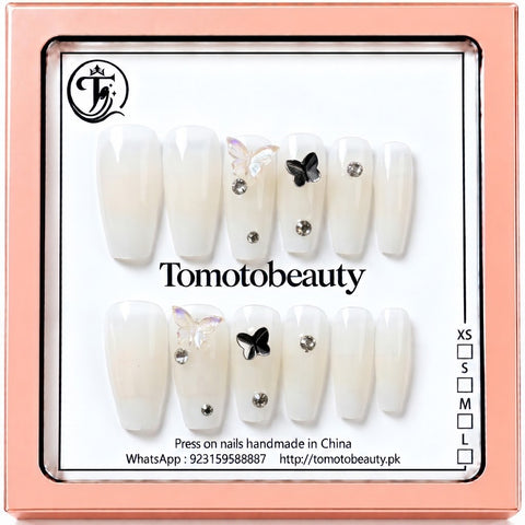 Tomoto Beauty C101 – Ivory White Butterfly Crystal Press On Nails. Milky ivory white coffin-style nails featuring delicate iridescent butterflies, a black butterfly accent and sparkling silver rhinestones.