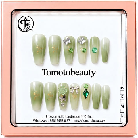 Tomoto Beauty C104 – Sage Green Ombré Crystal Press On Nails. Soft sage green and ivory ombré nails embellished with emerald green gems, metallic butterflies, a flower and subtle gold accents.