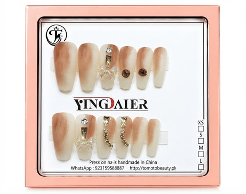Tomoto Beauty C108 – Caramel Cream Ombré Crystal Bow Press On Nails. Warm caramel-to-ivory ombré press-on nails with transparent ribbon bow detail, crystal rhinestones and fine gold accents.